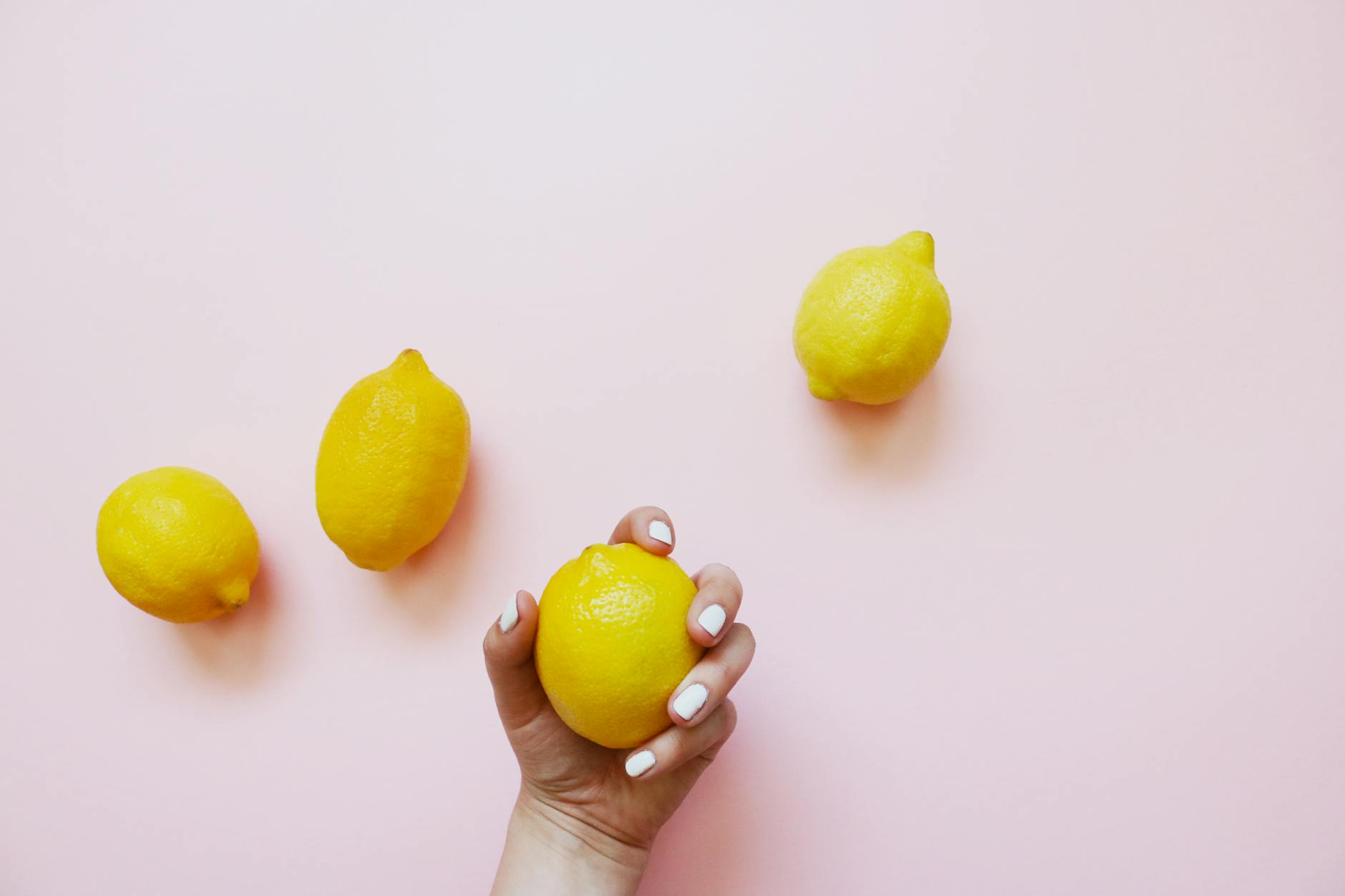 Ripe yellow lemons arranged on a bright yellow background in studio lighting