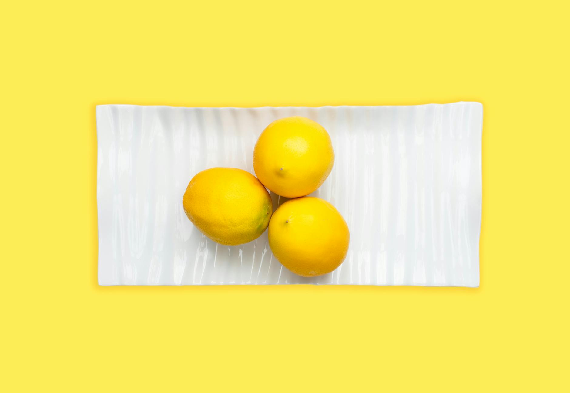 Woman holding lemon clitoral vibrators in contemplative pose, representing choice and self-directed pleasure