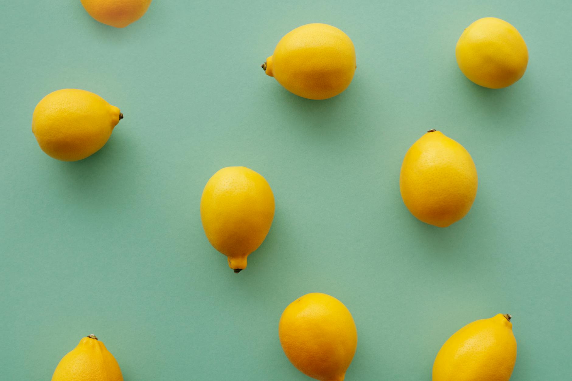 Bright yellow lemons on a soft green background, symbolizing fresh approaches to partnered pleasure and lemon vibrators