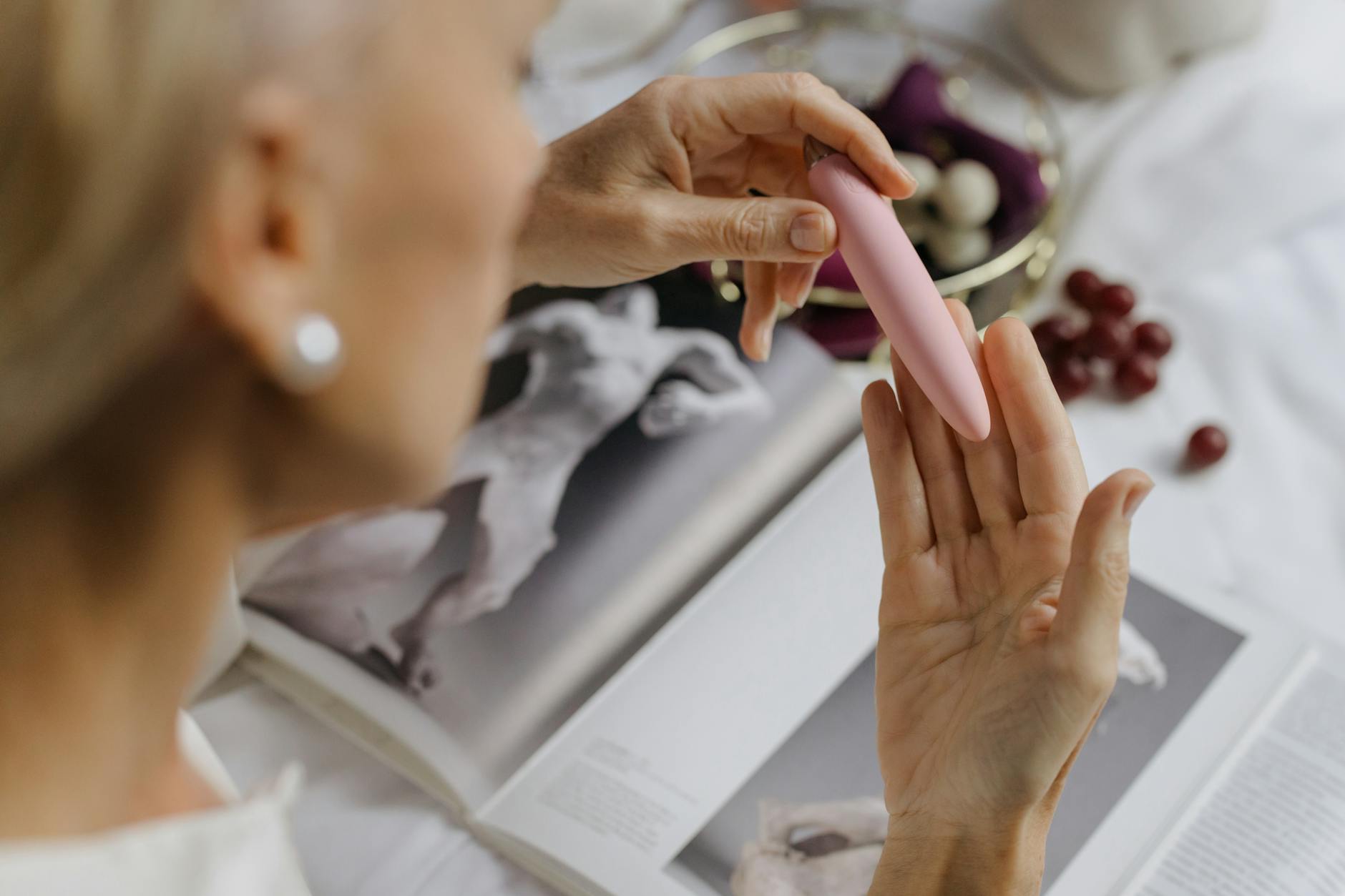 Close-up of hands holding a personal vibrator, emphasizing intimate wellness and postmenopausal pleasure